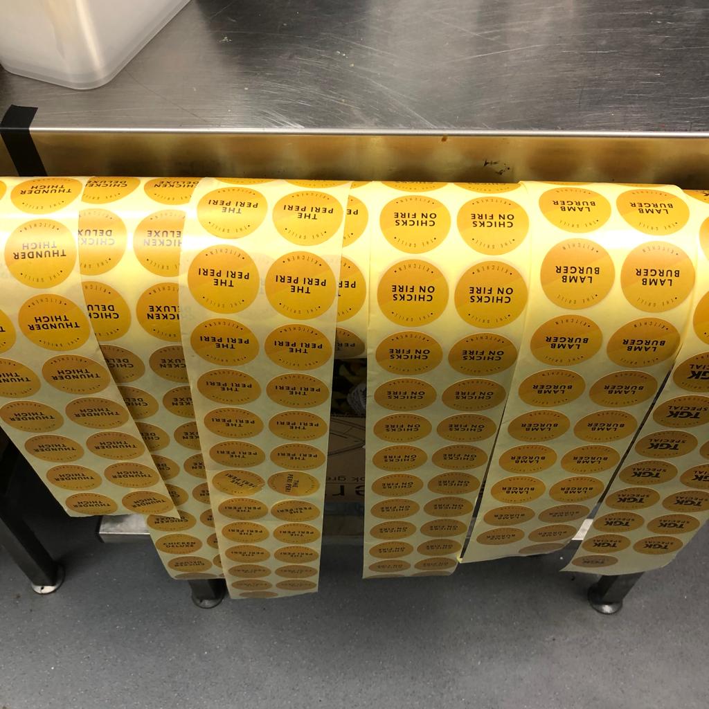 Burger labels applied to takeaway tubs and a roll